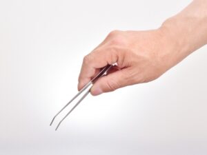 ピンセットを手に持つ